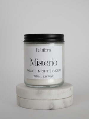 Pabilora Misterio scented candle: a sweet nocturnal blend of citrus and pear with a delicate floral heart of iris, jasmine, orange blossom, and violet, finished with a warm base of musk, amber, patchouli, vetiver, and vanilla.